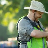 man putting on a lifejacket smiling